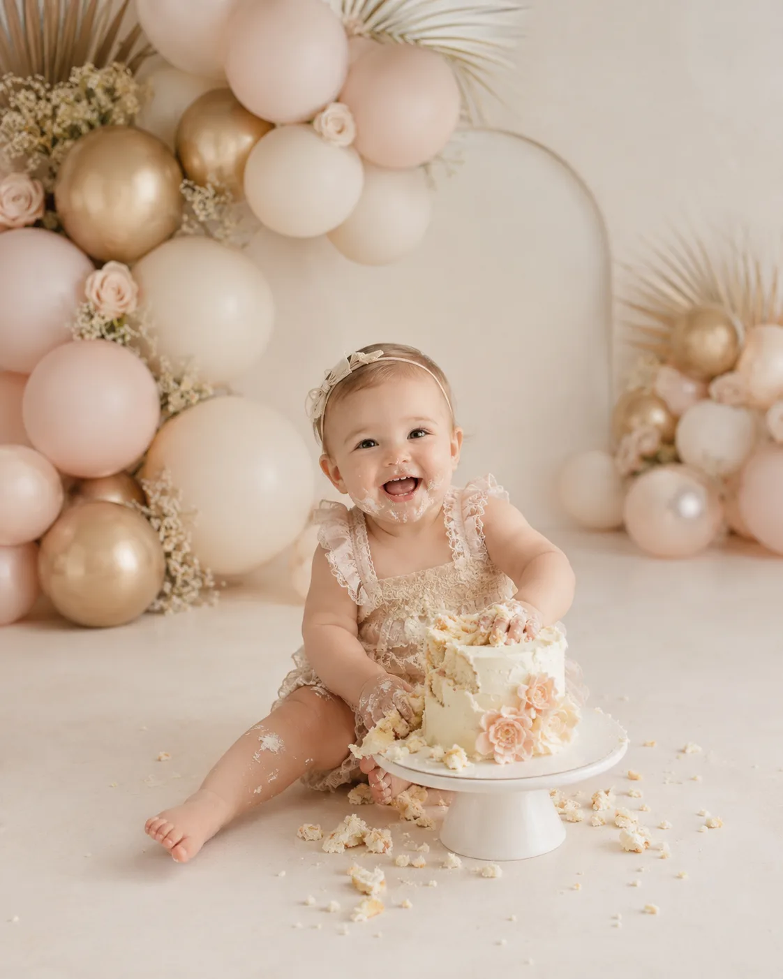 Laughing one-year-old covered in cake frosting during a Raleigh cake smash photography session